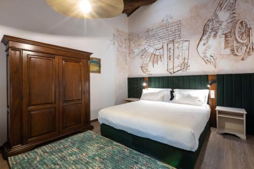 1 dormitorio con 1 cama y armario de madera en Castrum Wine Relais, en San Pietro in Cariano