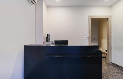 an office with a desk with a computer on it at Capital O GN Suites in Bengaluru