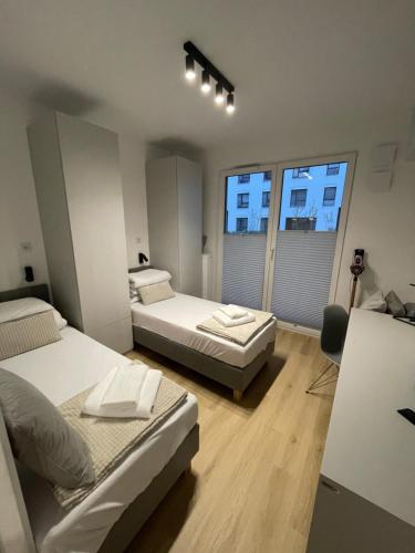 een slaapkamer met 2 bedden en een groot raam bij APARTAMENT 4 bed 2 room WARSAW in Warschau