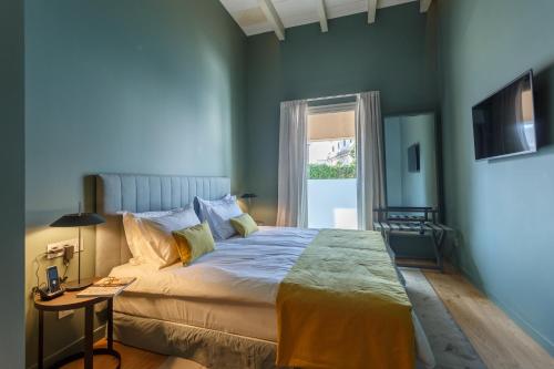 a blue bedroom with a large bed and a window at Bordoy Casa Ládico - Hotel Boutique Adults Only in Mahón