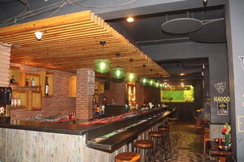 a bar in a restaurant with a row of stools at Kyriad Hotel Indore by OTHPL in Indore