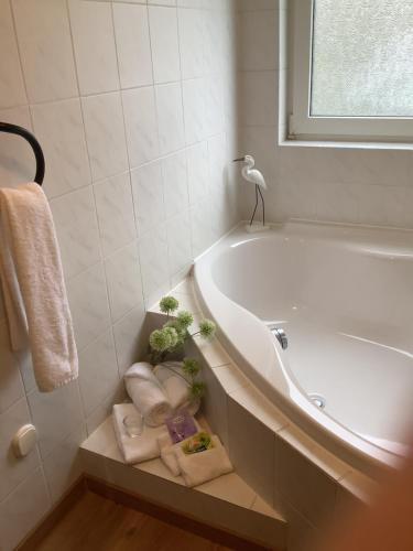 a bathroom with a tub and a pile of towels at Ferienwohnung SCHWARZACHHÖHE nur für Erwachsene in Wendelstein