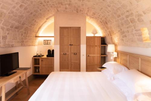 a bedroom with a bed and a tv in a room at Masseria Auraterrae in Polignano a Mare