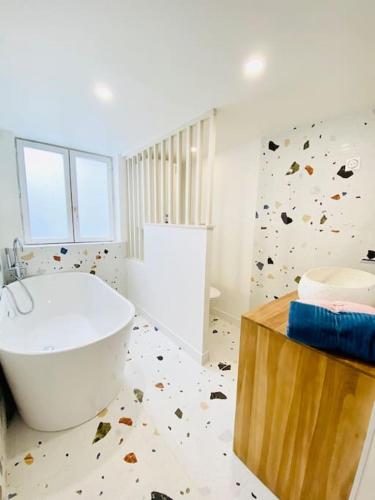 La salle de bains est pourvue d'une baignoire blanche et d'un mur en pierre. dans l'établissement Le Pop, à Rouen