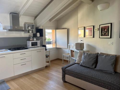 ein Wohnzimmer mit einem Sofa und einer Küche in der Unterkunft Casa161 in Bologna