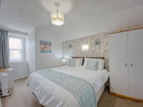 a bedroom with a large white bed and a window at Apartment 7 - 1 bedroom Sea front location - Step free access from rear - Free Parking in Paignton