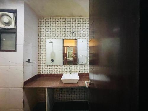Hotel Areeba by The Golden Taj Group & Hotels في آغْرا: حمام مع حوض ومرآة