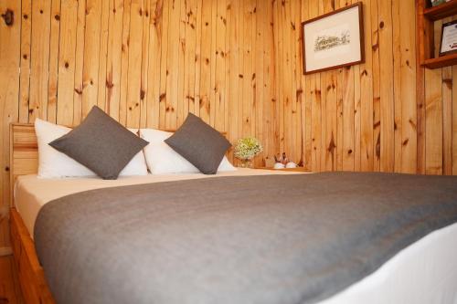 a bedroom with a bed with wood paneled walls at Lavender Dalat Hotel and Resorts in Da Lat