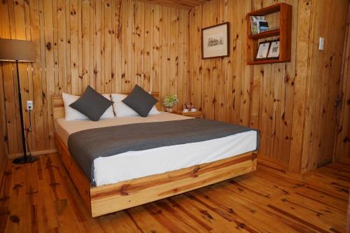 a bedroom with a bed in a wooden room at Lavender Dalat Hotel and Resorts in Da Lat