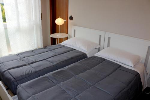 a bedroom with two beds and a window at EasyRoom Schio in Schio