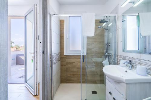 a bathroom with a glass shower and a sink at Villa Sele Fontanebianche - Nord in Fontane Bianche