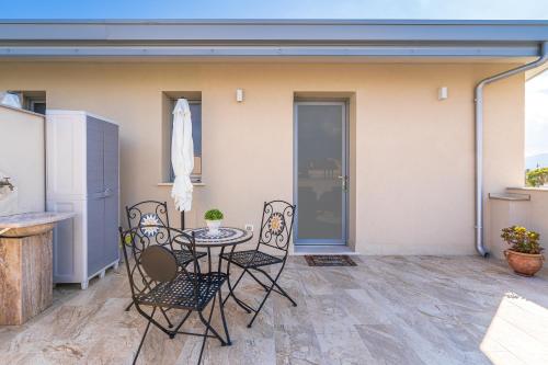 a patio with a table and chairs on a patio at Villa Sele Fontanebianche - Nord in Fontane Bianche