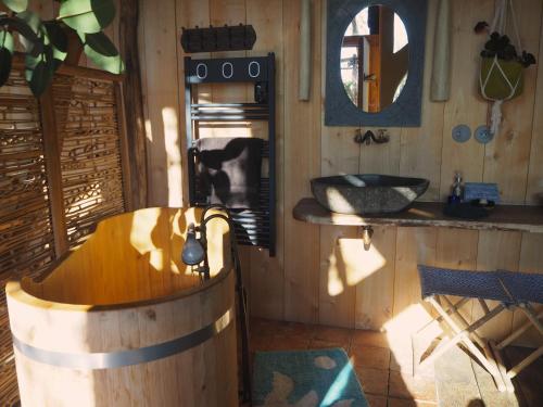 bagno con vasca in legno e lavandino di Ecolodge La Belle Verte a Saint-Mʼhervé