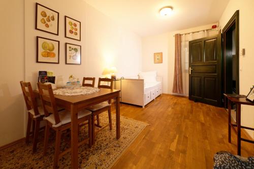 a dining room with a table and chairs and a bedroom at Kosbor Panzió in Magyarszombatfa