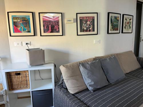 una sala de estar con sofá y algunas fotos en la pared en Casa161, en Bolonia