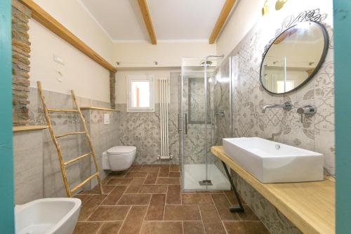 a bathroom with a sink and a toilet and a mirror at Al posto giusto -appartamento Gioia in Riotorto