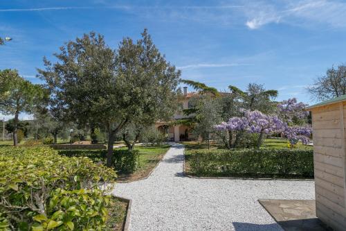 a garden with trees and a walkway at Al posto giusto - appartamento Sole in Riotorto