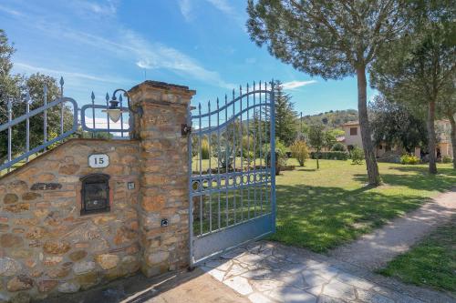 a gate with a stone fireplace next to a fence at Al posto giusto - appartamento Sole in Riotorto