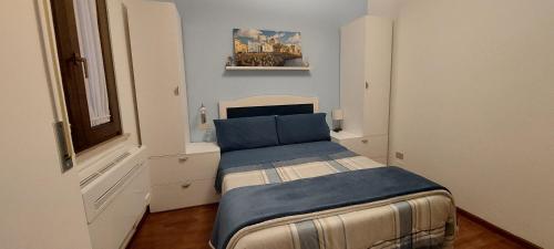 a small bedroom with a bed with a blue blanket at La Casa Blanca in Grottammare