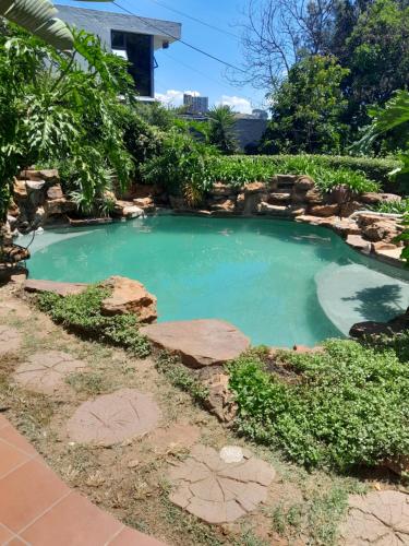a pool of water with rocks in a yard at KLOOFIES GUESTHOUSE in Roodepoort
