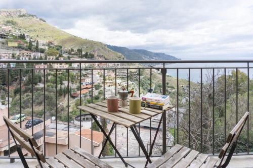 una mesa en un balcón con vistas al agua en Nonna Peppina Central Apartments, en Taormina