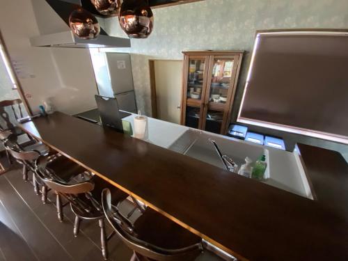 a long counter in a room with chairs and a sink at 山鹿師蔵 in Yamaga
