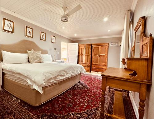 1 dormitorio con cama, mesa y piano en Primo farm, en Paarl