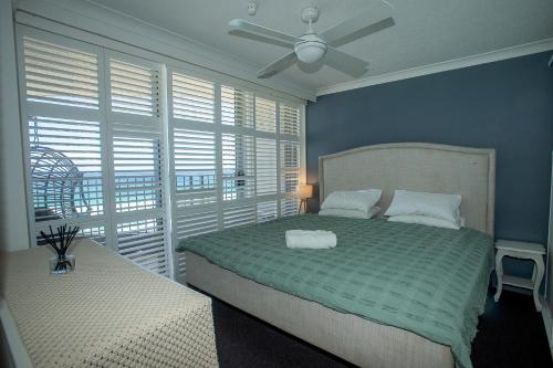 a bedroom with a bed and a ceiling fan at ABSOLUTELY STUNNING! ON THE BEACH !!! in Gold Coast