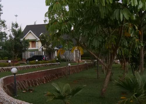 a house with a fence in front of a yard at Smart Eagle Apartment in Eldoret