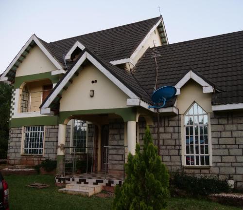 uma casa com um telhado preto em Smart Eagle Apartment em Eldoret