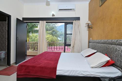 um quarto com uma cama e uma janela grande em Bharat Resorts em Dehradun