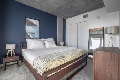 a bedroom with a bed and a blue wall at Lower Nob Hill 2BR w Roofdeck BBQ WD nr SFMH SFO-283 in San Francisco