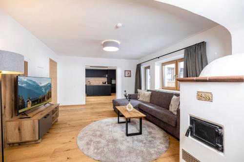 a living room with a couch and a tv at Apartments Austria in Söll
