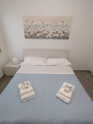 a white bed with two towels on top of it at RiDi Home Zona Ospedaliera in Naples