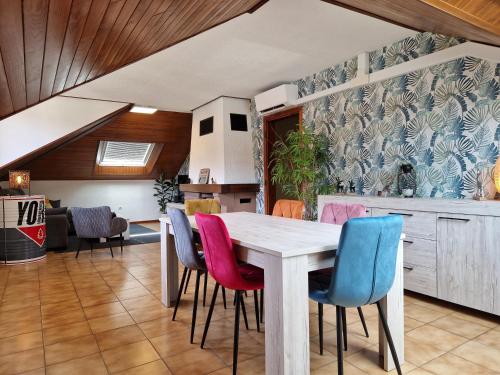 une cuisine avec une table et des chaises colorées dans l'établissement L'école buissonnière, à Dabo