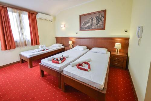 布德瓦的住宿－Dolce Vita，酒店客房,设有两张床,铺有红地毯。