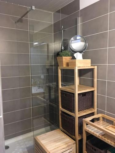 La salle de bains est pourvue d'une douche, d'un miroir et de paniers. dans l'établissement Appartement T3 proche de la mer, à Narbonne