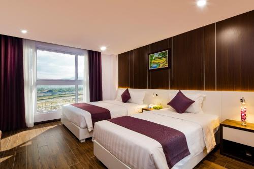 ein Hotelzimmer mit 2 Betten und einem Fenster in der Unterkunft Morris Hotel Nha Trang in Nha Trang