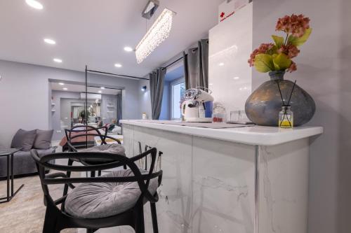 a kitchen with a counter with chairs and a vase with flowers at MM Rooms in Bled