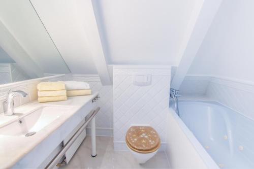 uma casa de banho branca com um WC e uma banheira em Abaco 2N - a83653 em Wenningstedt