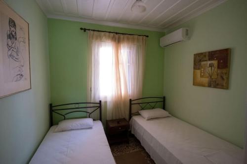 2 camas en una habitación con ventana en Σπίτι πάνω στο κύμα, en Katakolon