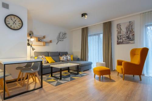 ein Wohnzimmer mit einem Sofa, einem Tisch und Stühlen in der Unterkunft RentPlanet - Apartamenty Górna Resorts in Szklarska Poręba