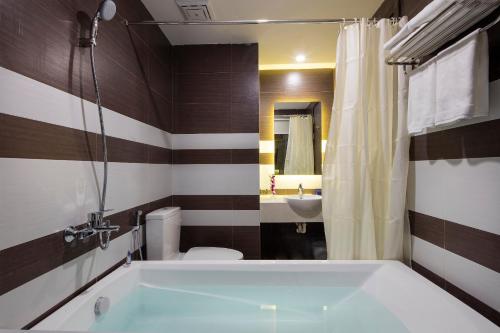 ein Badezimmer mit einer Badewanne, einem WC und einem Waschbecken in der Unterkunft Morris Hotel Nha Trang in Nha Trang