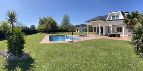 una casa con piscina en un patio en Villa LA PERLA con piscina privada, en Parbayón