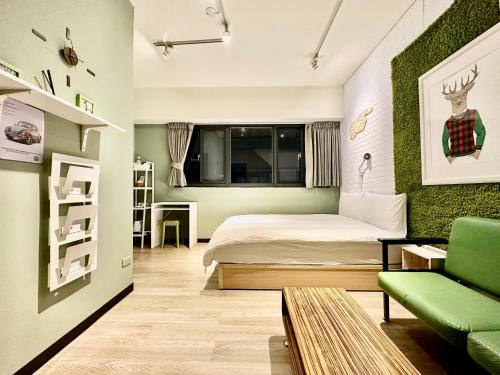 1 dormitorio con cama y pared de acento verde en 御旅 Inn en Taichung