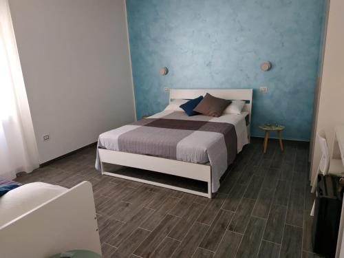 een slaapkamer met een bed en een blauwe muur bij Le camere......di via Vanoni in Termoli