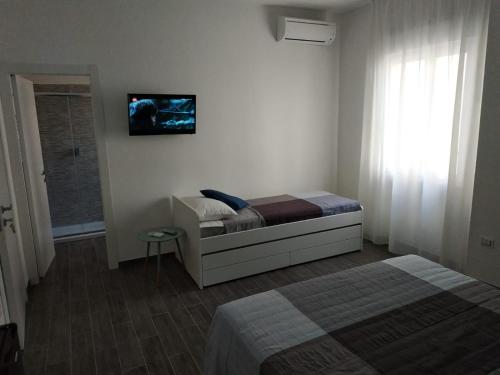 een slaapkamer met een bed en een televisie aan de muur bij Le camere......di via Vanoni in Termoli