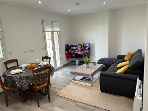 a living room with a couch and a table at House with terrace près de l'Aéroport RoissyCDG - Tour Eiffel - Champs Elysée - Paris - Aéroville centre commercial - Parc Astérix - Disneyland Paris - Mer de sable - Châteaux de Chantilly et Ecouen - Parc des expositions Villepinte - Le Bourget in Le Thillay