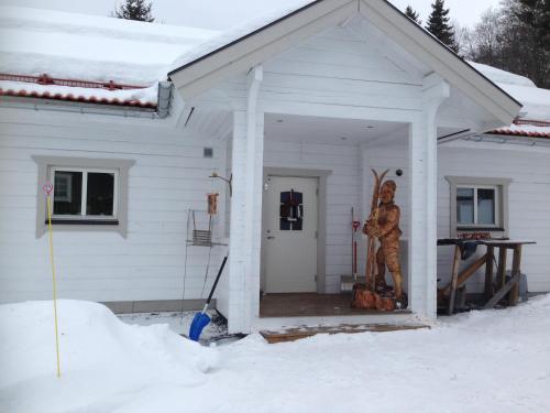 a house with a statue of a man with skis on the porch at BraHus Edvin 12 in Åre