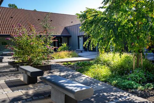 a garden with benches and trees and a building at Skanderborg Park in Skanderborg